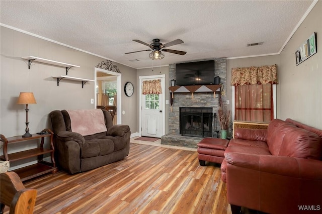 12569 Covered Bridge Rd, Brookwood, AL 35444 - living area featuring a textured ceiling, ornamental molding, a ceiling fan, light wood-style flooring, and a fireplace