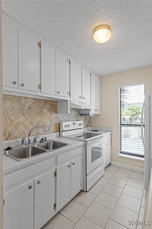 1500 W Beach Blvd Unit 212, Gulf Shores, AL 36542 - laundry area with baseboards, a sink, a textured ceiling, and light tile patterned floors