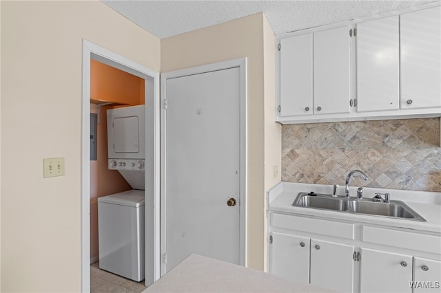 1500 W Beach Blvd Unit 212, Gulf Shores, AL 36542 - washroom featuring light tile patterned floors, laundry area, stacked washer / dryer, and a sink