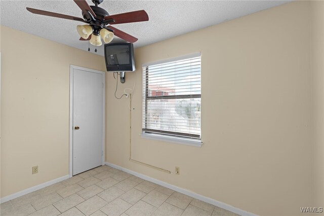 1500 W Beach Blvd Unit 212, Gulf Shores, AL 36542 - spare room featuring a ceiling fan, baseboards, and a textured ceiling