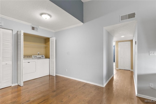 laundry area featuring visible vents, laundry area, washing machine and dryer, and wood finished floors