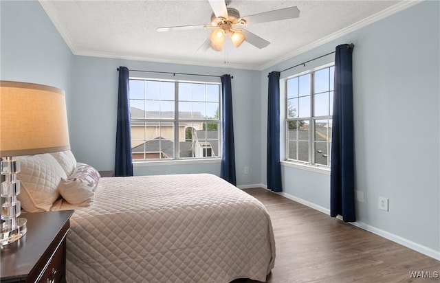 bedroom featuring baseboards, a textured ceiling, ornamental molding, and wood finished floors