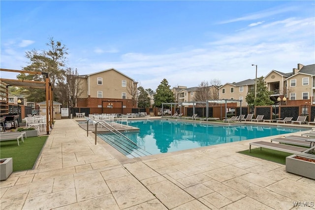 pool featuring a pergola, fence, a residential view, and a patio