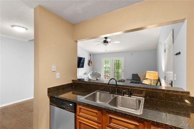 kitchen with brown cabinets, a sink, dishwasher, a ceiling fan, and open floor plan