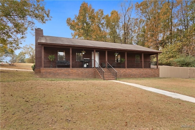 single story home featuring a porch, a chimney, and a front yard