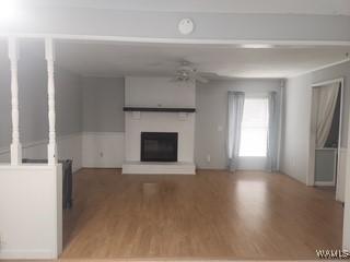 2417 Dvorak Cir, Linden, AL 36748 - unfurnished living room with a glass covered fireplace and light wood-style floors