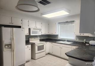 2417 Dvorak Cir, Linden, AL 36748 - kitchen with white appliances, dark countertops, and a peninsula