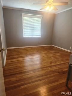 2417 Dvorak Cir, Linden, AL 36748 - empty room featuring wood finished floors, ceiling fan, and crown molding