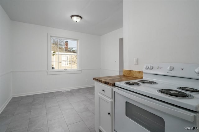 kitchen with white cabinetry, white electric stove, and light tile patterned flooring