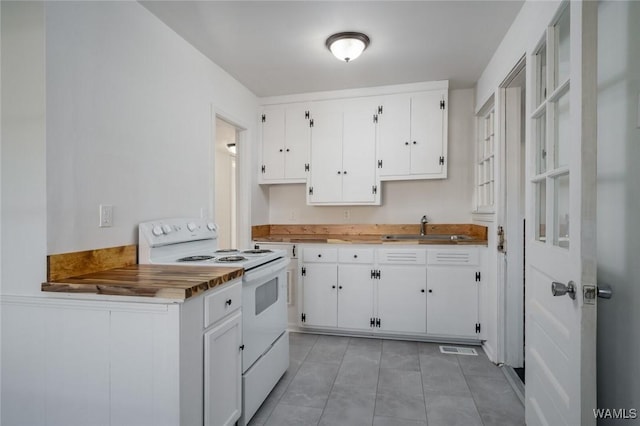 kitchen with white cabinetry, light tile patterned flooring, electric stove, and sink