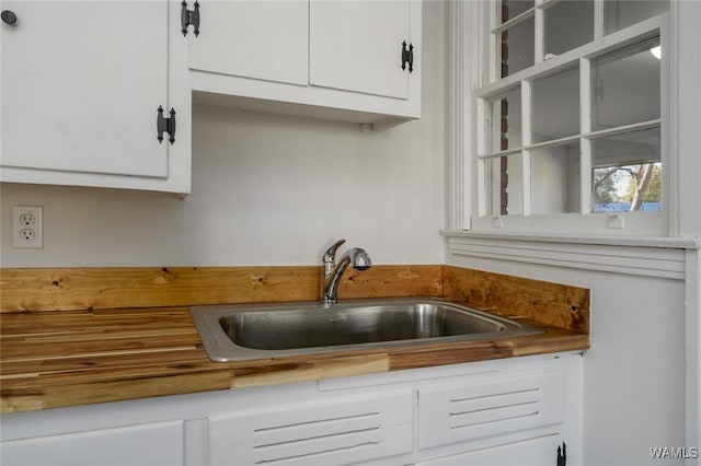 kitchen featuring white cabinets and sink