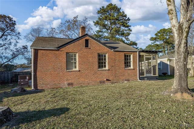 rear view of property featuring a lawn