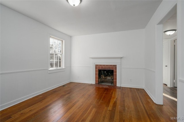 unfurnished living room featuring dark hardwood / wood-style flooring and a tile fireplace