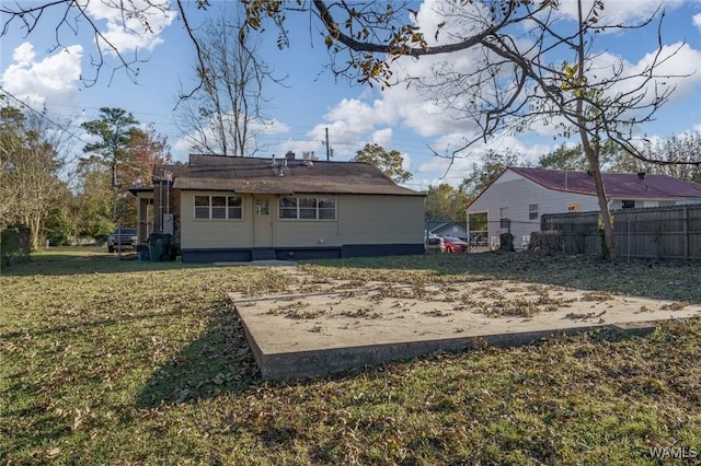 rear view of property with a lawn