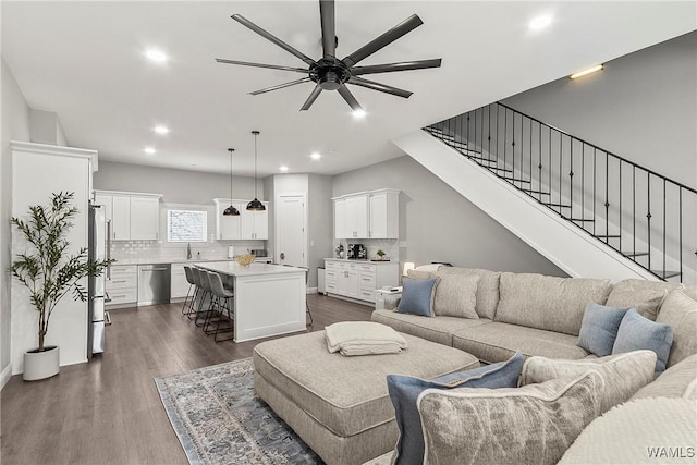 living room featuring dark wood-type flooring, recessed lighting, stairway, and a ceiling fan