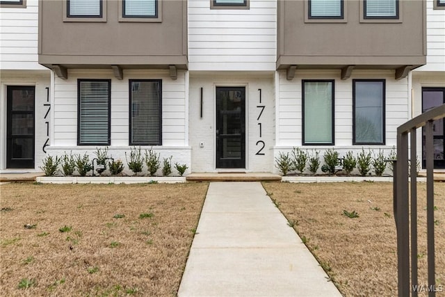 view of exterior entry featuring a yard