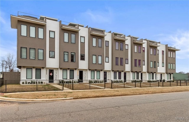 view of building exterior with a residential view and fence