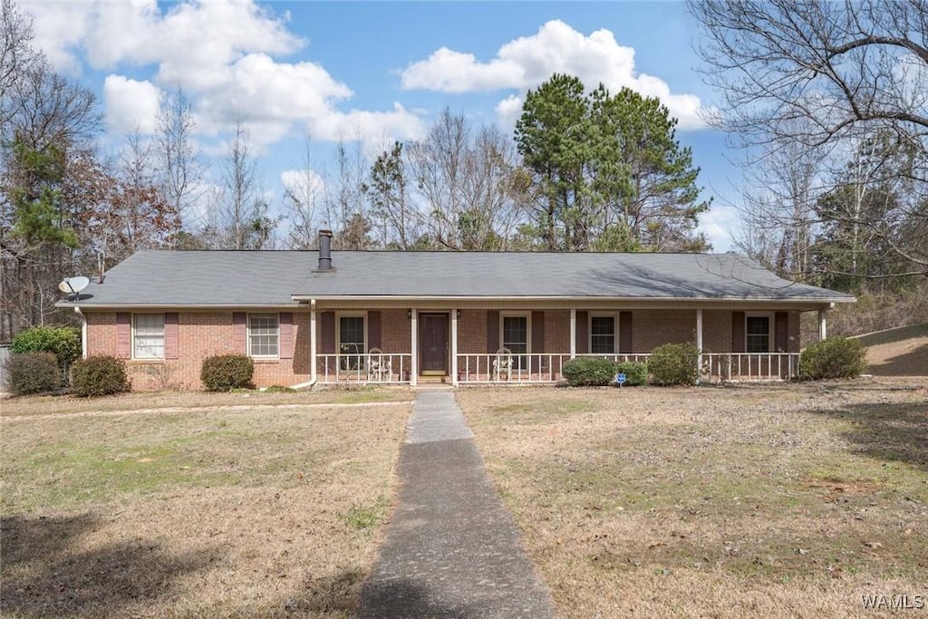 ranch-style home featuring a front yard and covered porch