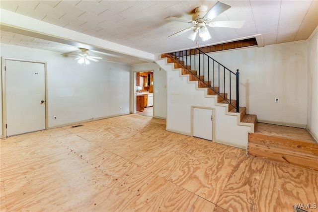 interior space featuring visible vents, baseboards, ceiling fan, and stairway