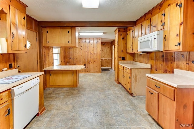 kitchen with wood walls, brown cabinets, light countertops, a peninsula, and white appliances