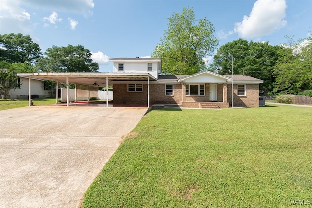 view of front of property featuring fence, a front yard, brick siding, driveway, and a carport