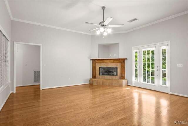 4713 Northwood Lake Dr E, Northport, AL 35473 - unfurnished living room featuring wood finished floors, crown molding, baseboards, a ceiling fan, and a tiled fireplace