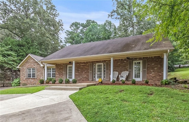 4713 Northwood Lake Dr E, Northport, AL 35473 - ranch-style home with a porch, a front lawn, and brick siding