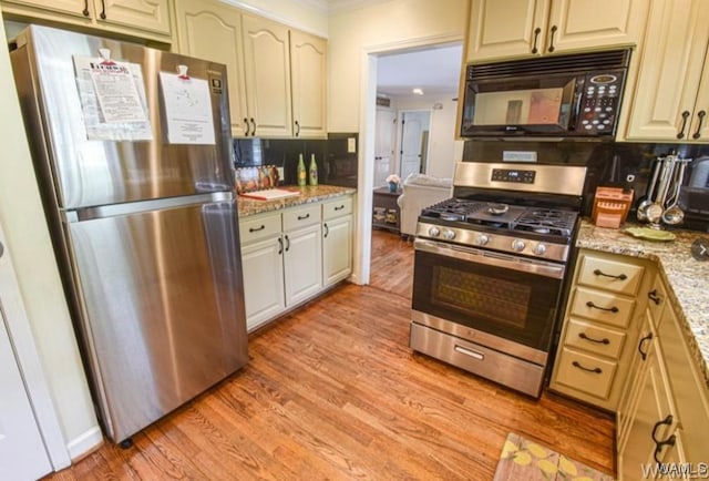 16584 Kathryn Lane Dr, Northport, AL 35475 - kitchen with stainless steel appliances, ornamental molding, light wood-type flooring, and light stone counters