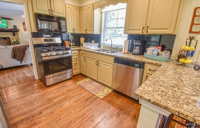 16584 Kathryn Lane Dr, Northport, AL 35475 - kitchen featuring appliances with stainless steel finishes, a sink, light wood-type flooring, and light stone counters