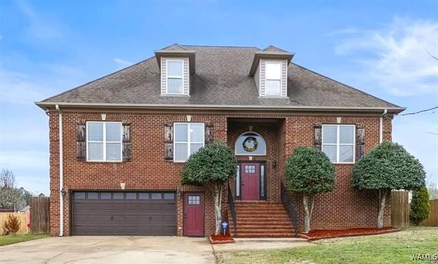 10821 Dogwood Cir, Vance, AL 35490 - view of front of house featuring roof with shingles, a garage, brick siding, and driveway