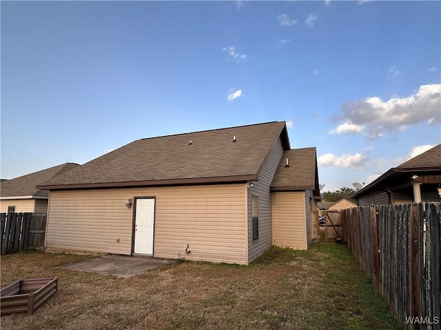 rear view of property featuring a lawn and a patio