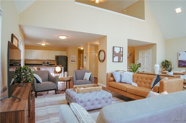 living area featuring baseboards and high vaulted ceiling