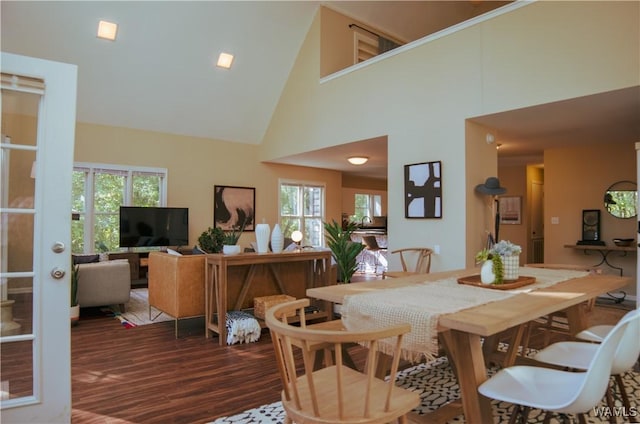 dining area featuring high vaulted ceiling and dark wood-type flooring