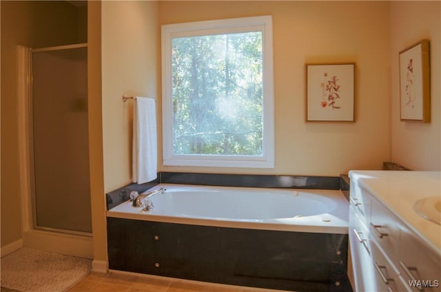 full bathroom with vanity, a shower stall, and a bath