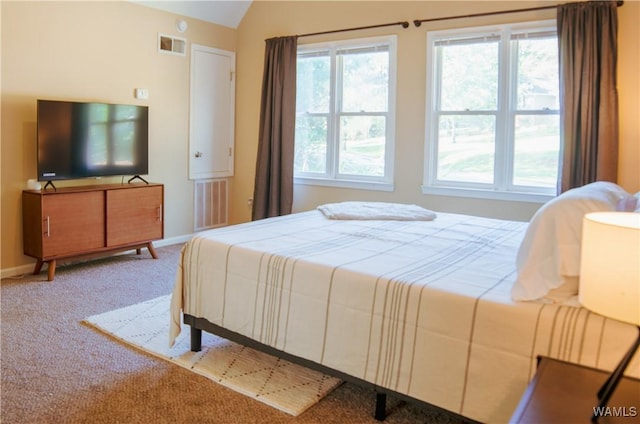 carpeted bedroom with lofted ceiling, visible vents, and multiple windows