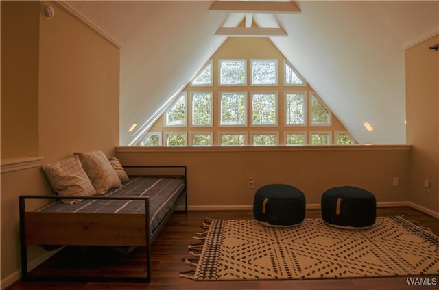 living area with vaulted ceiling, baseboards, and wood finished floors