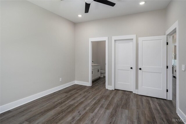 unfurnished bedroom featuring ceiling fan, dark hardwood / wood-style flooring, and ensuite bath