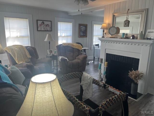 living area with crown molding, ceiling fan, and wood finished floors