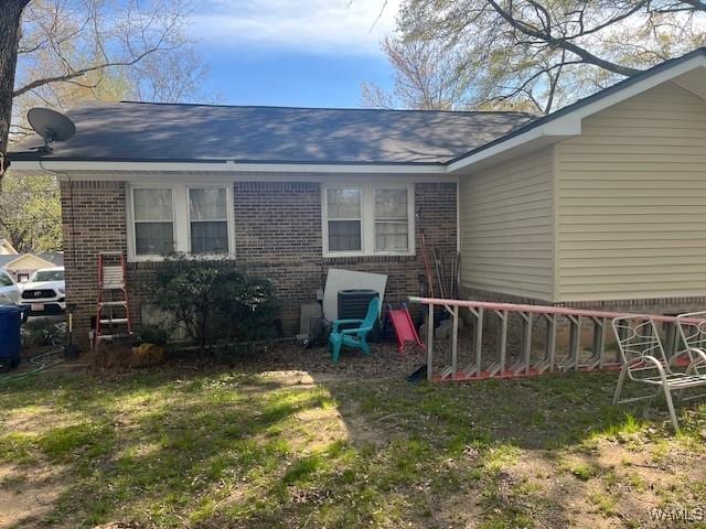 rear view of property with brick siding