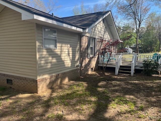 view of side of home with a wooden deck and crawl space