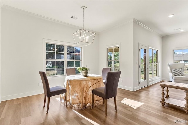 dining room featuring a chandelier, ornamental molding, and hardwood / wood-style flooring