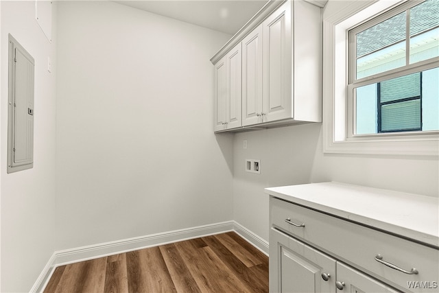 clothes washing area featuring cabinets, washer hookup, electric panel, and dark wood-type flooring