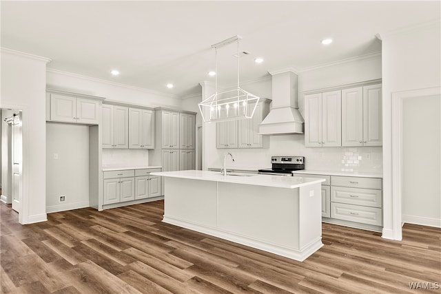 kitchen featuring custom range hood, stainless steel electric stove, dark wood-type flooring, and an island with sink