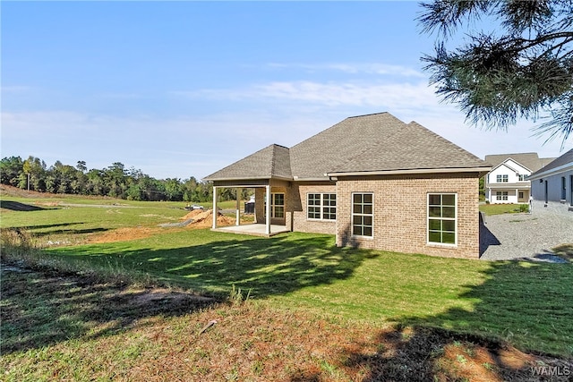 back of property with a yard and a patio area