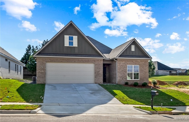 craftsman inspired home featuring a garage and a front lawn