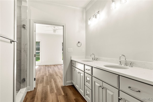 bathroom featuring ornamental molding, a tile shower, vanity, ceiling fan, and hardwood / wood-style flooring