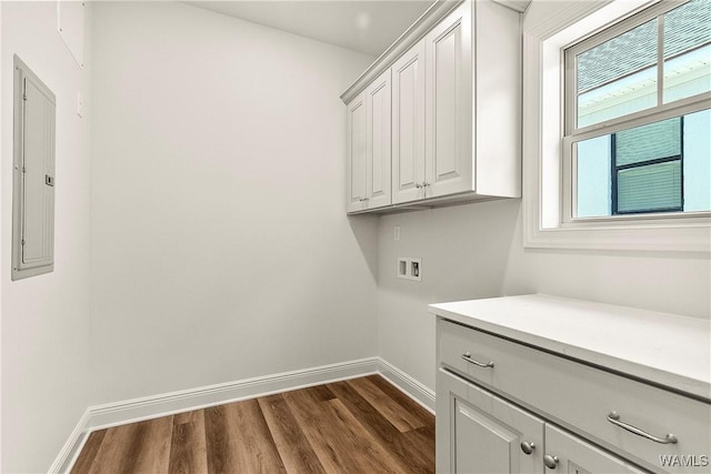 washroom featuring electric panel, cabinets, hookup for a washing machine, and dark wood-type flooring