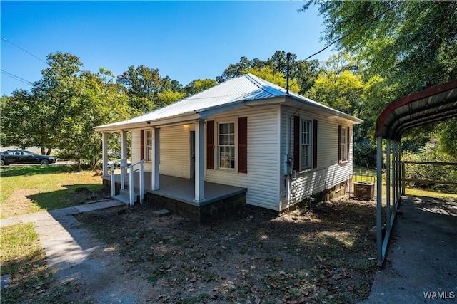 view of property exterior with central AC unit, covered porch, and metal roof