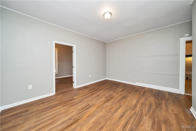 empty room with baseboards and wood finished floors