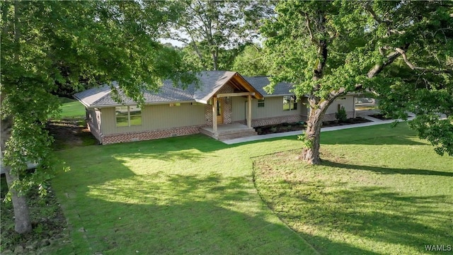 view of front facade with a front lawn and a shingled roof